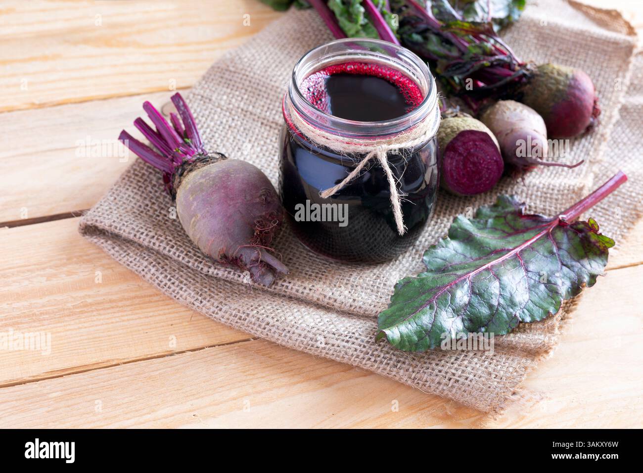 Ein Glas frischen Rote-Bete-Saft mit Gemüse auf hellem Hintergrund Stockfoto