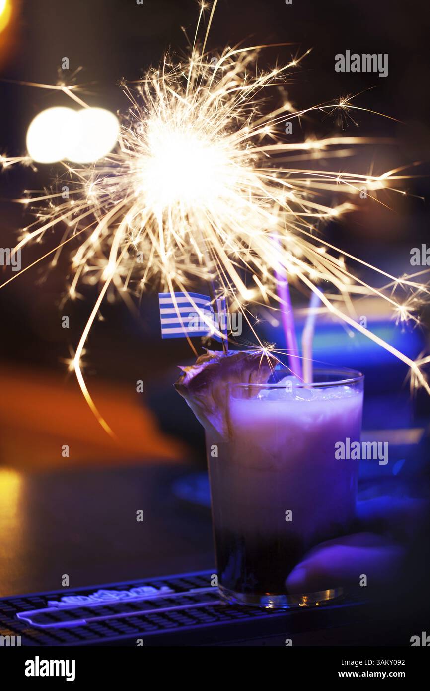 Wunderschönes bengalisches Licht im Cocktailglas mit griechischer Flagge Stockfoto