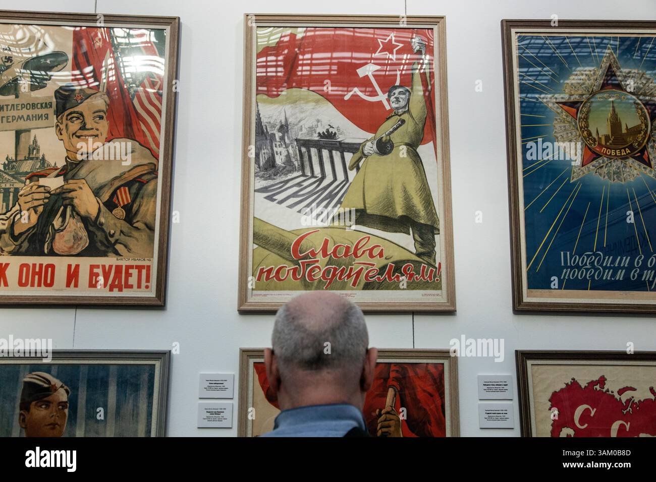 Moskau, Russland. April 2025. Ein Mann sieht eine Ausstellung sowjetischer Plakate aus dem Großen Vaterländischen Krieg von 1941-1945 auf der internationalen Buchmesse für hochwertige Fiktion und Sachbücher im Messezentrum Gostiny Dvor in Moskau Stockfoto