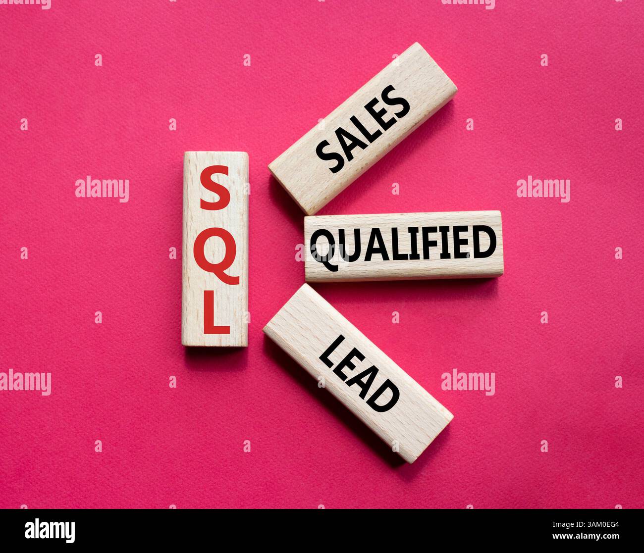 SQL - qualifizierter Lead für Vertrieb. Holzwürfel mit SQL-Wörtern. Schöner roter Hintergrund. Business- und SQL-Konzept. Kopierbereich. Stockfoto