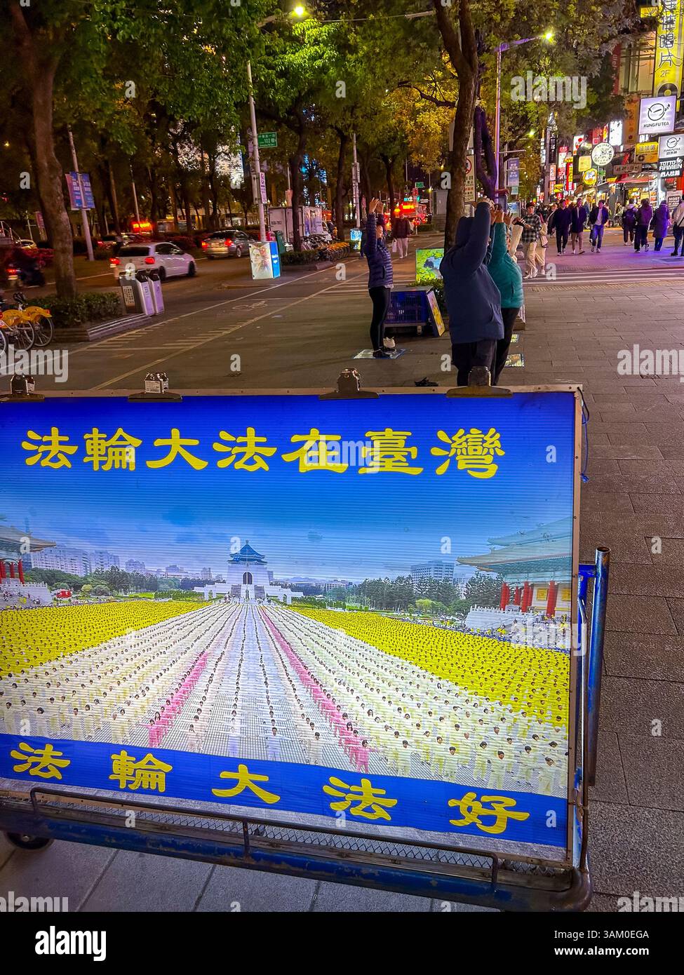 Taipeh, Taiwan, Gruppenmenschen, Draußen, Fulan Gong, religiöse Sekte, Kampagne auf Straßenszene, Stadtzentrum, Nacht, Detail Propagandabild Stockfoto