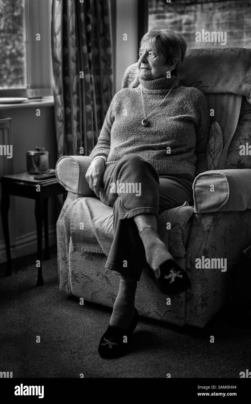 Eine 90-jährige Dame, die in ihrem Sessel sitzt Stockfoto