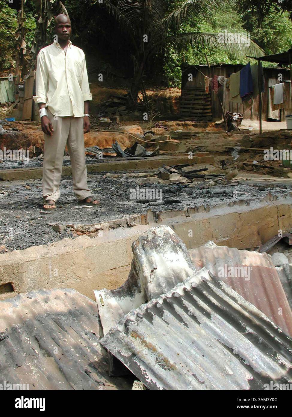 1. Februar 2003 - USA - KRT WORLD NEWS STORY SLUGGED: IVORYCOAST KRT FOTO VON SUDARSAN RAGHAVAN (9. Februar) Yaya Bamba, 24, ein ivorischer Westler steht vor seinem verbrannten Haus in Abidjan, Elfenbeinküste. Yaya ist eine von vielen Einwanderern und Ivorern aus dem Norden und Westen der Rebellen, deren Häuser von Gendarmen der Regierung zerstört wurden. (nk) 2003 (Kreditbild: © Sudarsan Raghavan/mct/ZUMAPRESS.com) Stockfoto