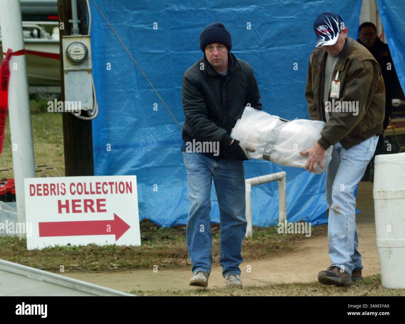7. Februar 2003 - USA - KEINE KARTEN, KEINE VERKÄUFE -- KRT US NEWS STORY SCHLEPPTE: SHUTTLE KRT FOTO VON MICHAEL MULVEY/DALLAS MORNING NEWS (7. Februar) HEMPHILL, TX - Beamte transportieren am 7. Februar 2003 ein gewickeltes Stück Trümmer vom Space Shuttle Columbia zu einem wartenden Van in Hemphill, Texas. (gsb) 2003 (Bild: © Michael Mulvey/mct/ZUMAPRESS.com) Stockfoto