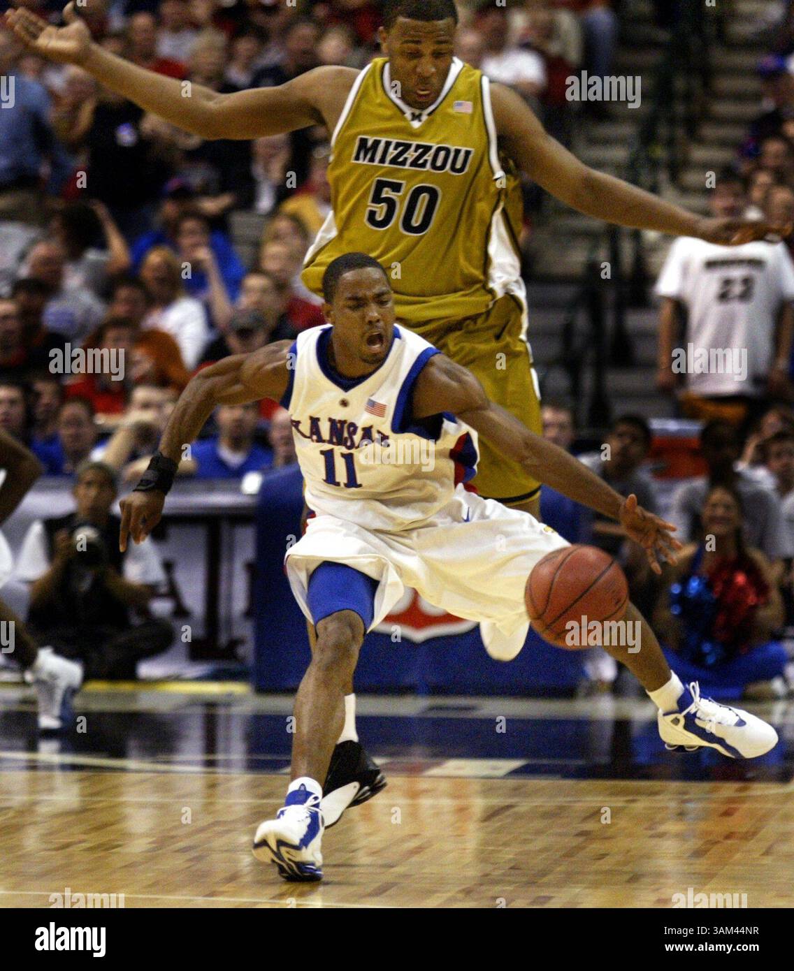 12. März 2004 - USA - KEINE MAGIE, KEINE VERKÄUFE -- KRT SPORTS STORY SCHLEPPTE: MISSOURI-KANSAS KRT FOTO VON LOUIS DeLuca/DALLAS MORNING NEWS (12. März) DALLAS, TX -- Aaron Miles (11) aus Kansas jagt einen losen Ball mit Arthur Johnson (50) der University of Missouri in der ersten Halbzeit beim Big 12 Turnier im American Airlines Center in Dallas, Texas, am 12. März 2004. (cdm) 2004 (Kreditbild: © Louis Deluca/mct/ZUMAPRESS.com) Stockfoto