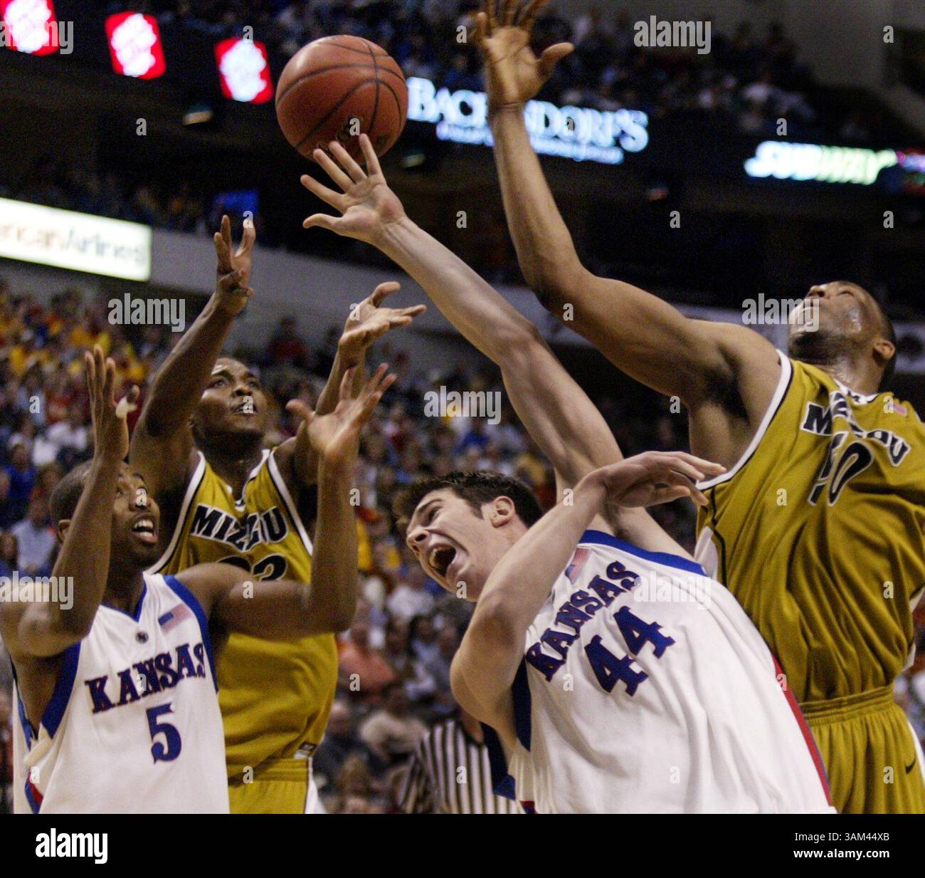 12. März 2004 - USA - KEINE MAGIE, KEIN VERKAUF - KRT SPORTS STORY SCHLEPPTE: MISSOURI-KANSAS KRT FOTO VON LOUIS DeLuca/DALLAS MORNING NEWS (12. März) DALLAS, TX - Keith Langford (5) und David Padgett (44) von Rickey Paulding (23) der Kansas Battle University of Missouri und Arthur Johnson (50) für eine Rebound eine Rebound eine Rebound die zweite Halbzeit des Big 12 Turniers im American Airlines Center in Dallas, Texas am 12. März 2004. (cdm) 2004 (Kreditbild: © Louis Deluca/mct/ZUMAPRESS.com) Stockfoto