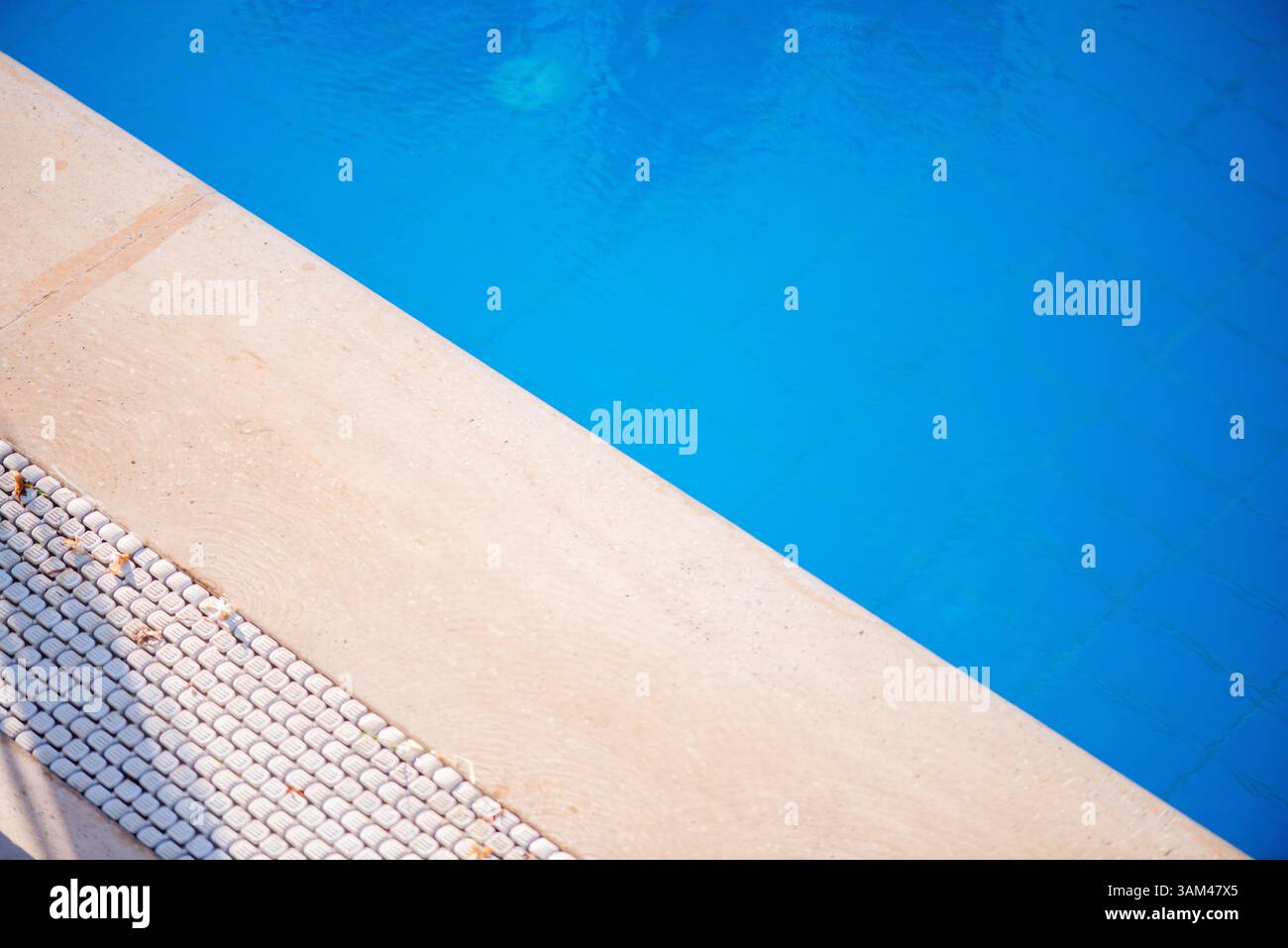 Eine Makroaufnahme aus Nahaufnahme, die die feinen Details einer Schwimmbadszene – Wasser, strukturierte Oberflächen und Lichtreflexionen – erfasst und die Summe bringt Stockfoto