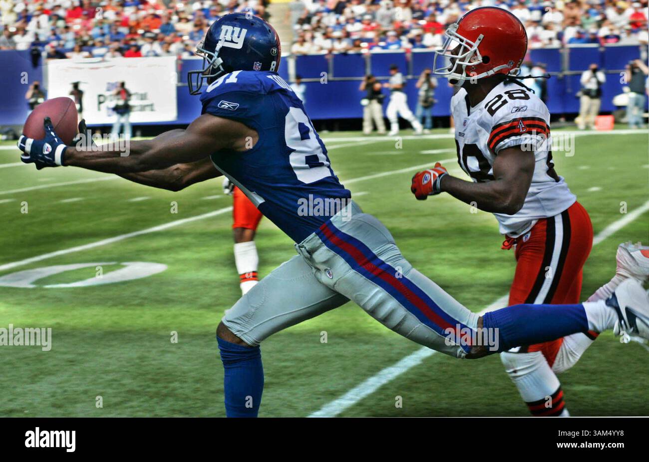26. September 2004 - USA - KRT SPORTS STORY SLUGGED: BROWNS-RIESEN KRT FOTO VON BOB DEMAY/AKRON BEACON JOURNAL (26. September) EAST RUTHERFORD, NJ -- New York Giants Wide Receiver Amani Toomer holt einen 35-Yard-Pass vom Quarterback Kurt Warner, während Leigh Bodden von den Cleveland Browns das Spiel im dritten Quartal verfolgt. Die Giants besiegten die Browns am Sonntag, den 26. September 2004, in den Meadowlands in East Rutherford, New Jersey. (cdm) 2004 (Kreditbild: © Bob Demay/mct/ZUMAPRESS.com) Stockfoto