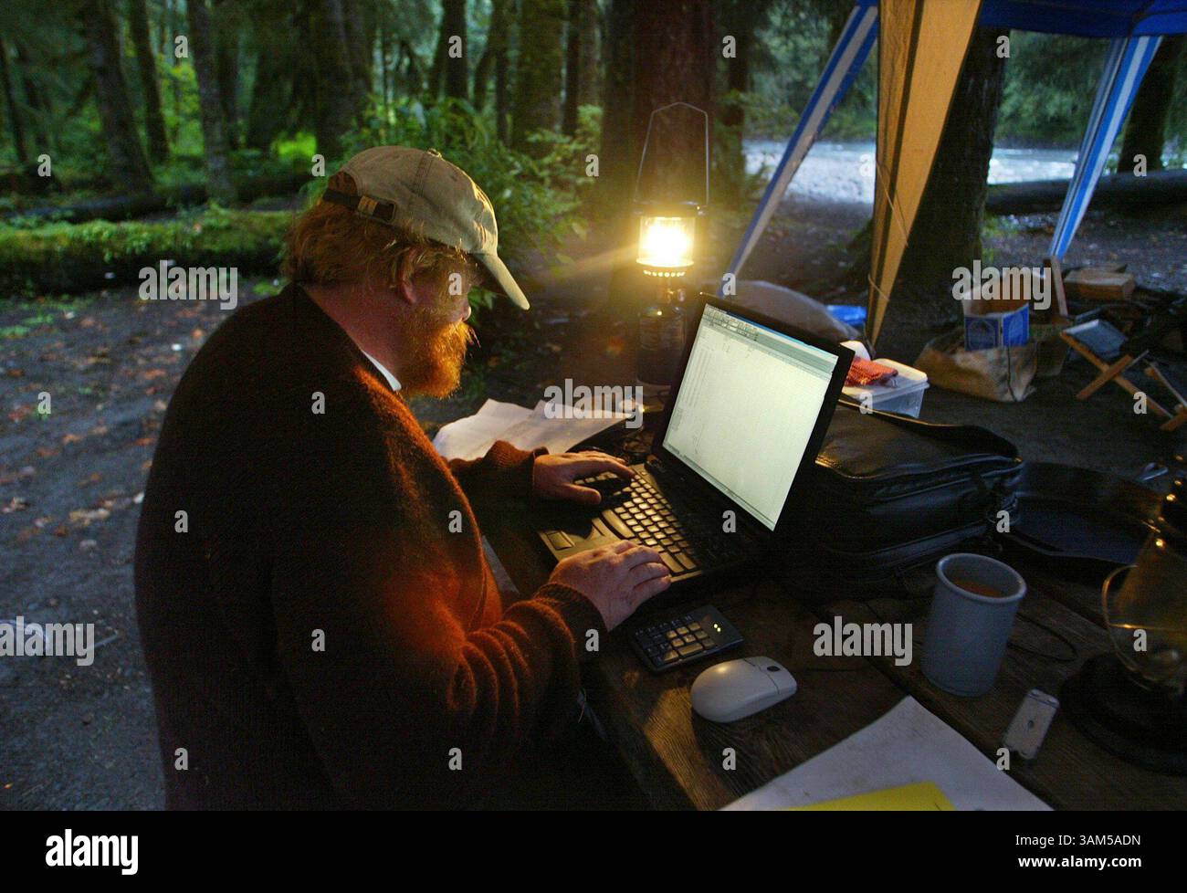 8. September 2004 - USA - KEINE MAGIE, KEINE VERKÄUFE -- KRT US-NEWS-STORY SCHLEPPTE: ENV-QUEETS KRT FOTO VON STEVE RINGMAN/SEATTLE TIMES (3. Februar) Robert Van Pelt sitzt an seinem Laptop, angetrieben von einer Bootsbatterie, um Daten vom Aufstieg des Vortages in das Walddach entlang des Queets River im Bundesstaat Washington aufzuzeichnen. (Mvw) 2005 (Bild: © Steve Ringman/mct/ZUMAPRESS.com) Stockfoto