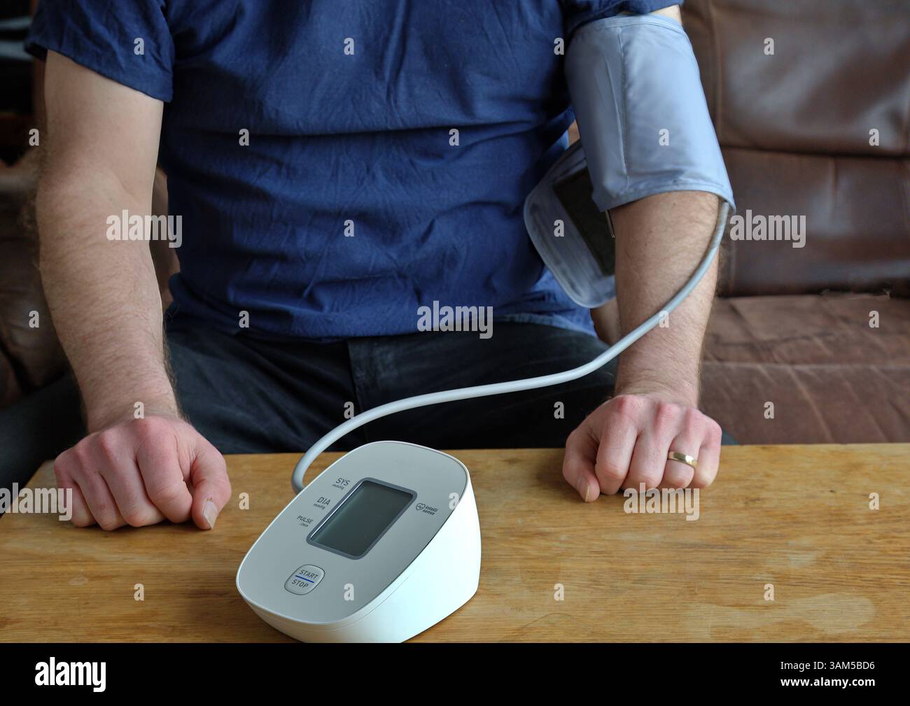 Mann seinen Blutdruck zu Hause überprüfen Stockfoto