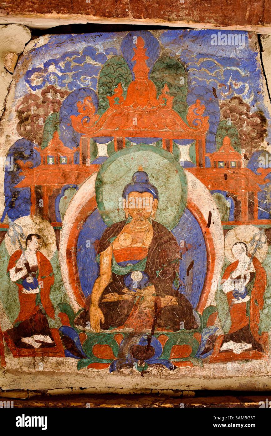 Verblasstes Wandgemälde eines sitzenden Buddhas, flankiert von Dienern im Innenhof des Hemis-Klosters, einer bedeutenden tibetisch-buddhistischen Stätte in Ladakh. Stockfoto