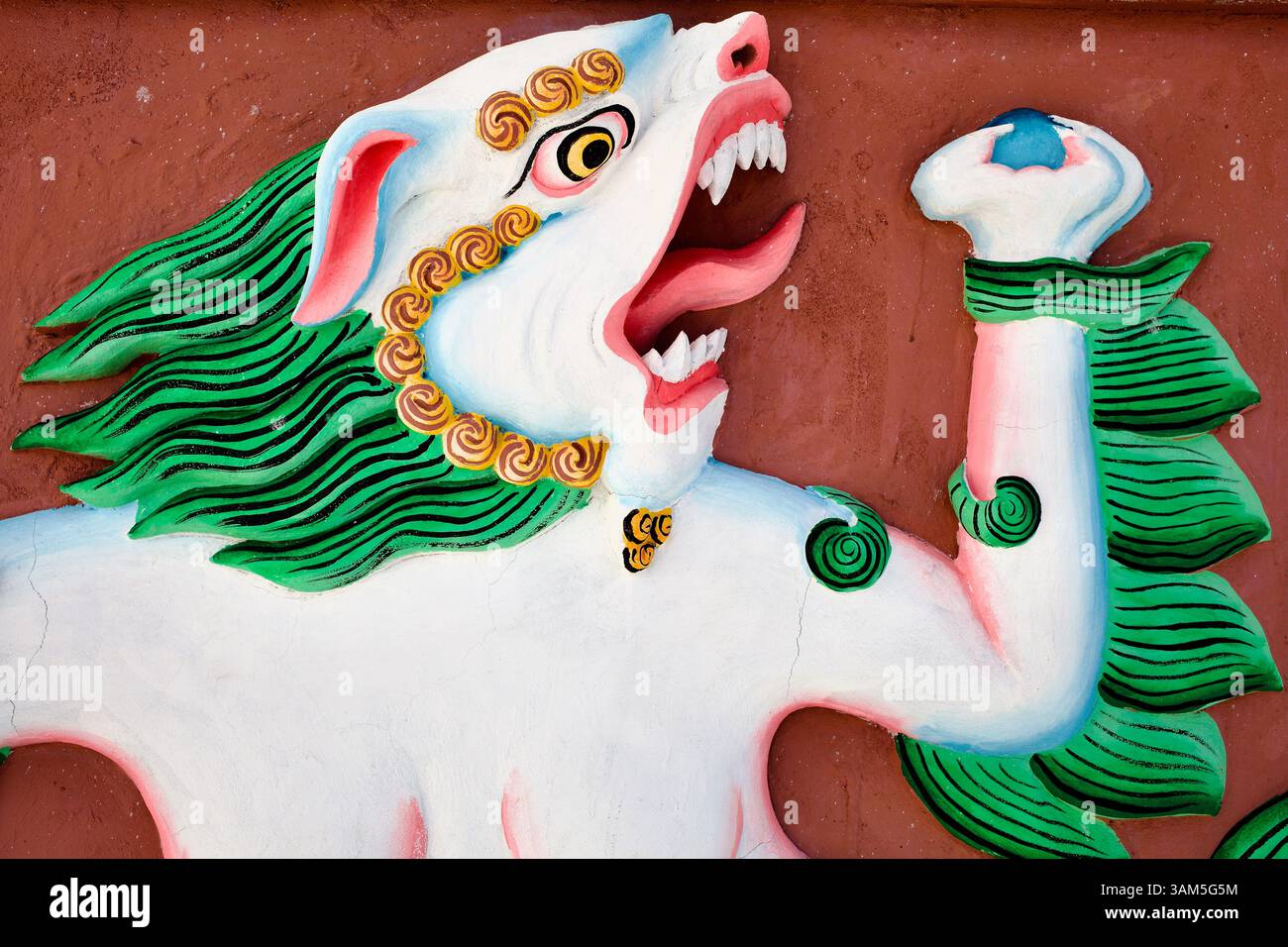 Wildes mythisches Schneelöwen Relief mit brennender Mähne und Juwel, gemalt auf rote Gipswand, Ladakh, Indien. Stockfoto