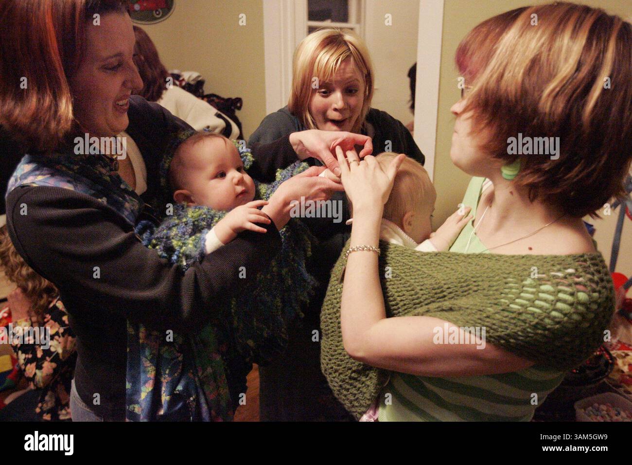 16. Februar 2005 - USA - KEINE MAGIE, KEINE VERKÄUFE - KRT LIFESTYLE STORY SCHLEPPTE: FAM-PUNKYMOMS KRT FOTO VON MICHAEL AINSWORTH/DALLAS MORNING NEWS (29. März) Cameron Pittman, links, und Beth Dalehite, Mitte, versuchen Grace Pittman, 8 Monate, davon abzuhalten, die Haare von Baby Taryn Lasater, 9 Monate, die von ihrer Mutter Kimmy Lasater während eines Punkymoms gehalten wird. Mitglieder trafen sich im Haus der Gründerin Jessica Seymour zum Backen und Sozialisieren. Diese Mütter (und einige Väter) treffen sich wöchentlich mittwochs in einem anderen Mitgliederhaus. (cdm) 2005 (Vielfalt) (Bild: © Michael Ainswo Stockfoto