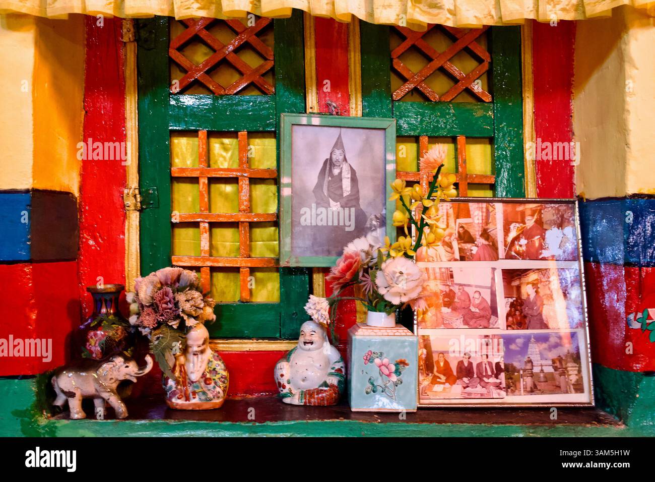 Porträtausstellung und Keramikvasen in einer bemalten Fensternische im Empfangsraum des Klosters Stakna, Ladakh. Stockfoto