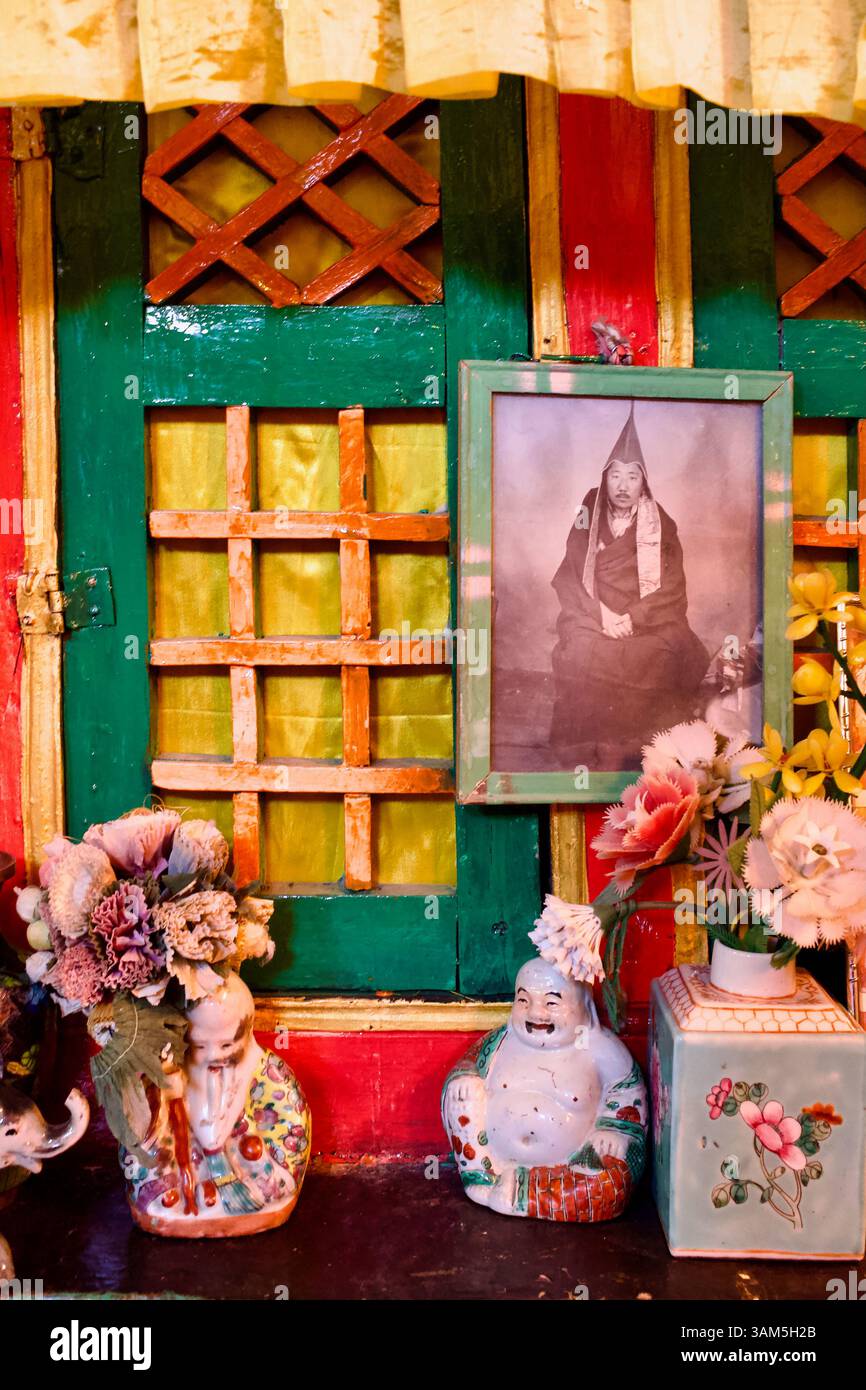 Gerahmtes Porträt eines älteren Mönchs neben Andachtsgegenständen in einer bemalten Nische im Stakna Kloster in Ladakh. Stockfoto