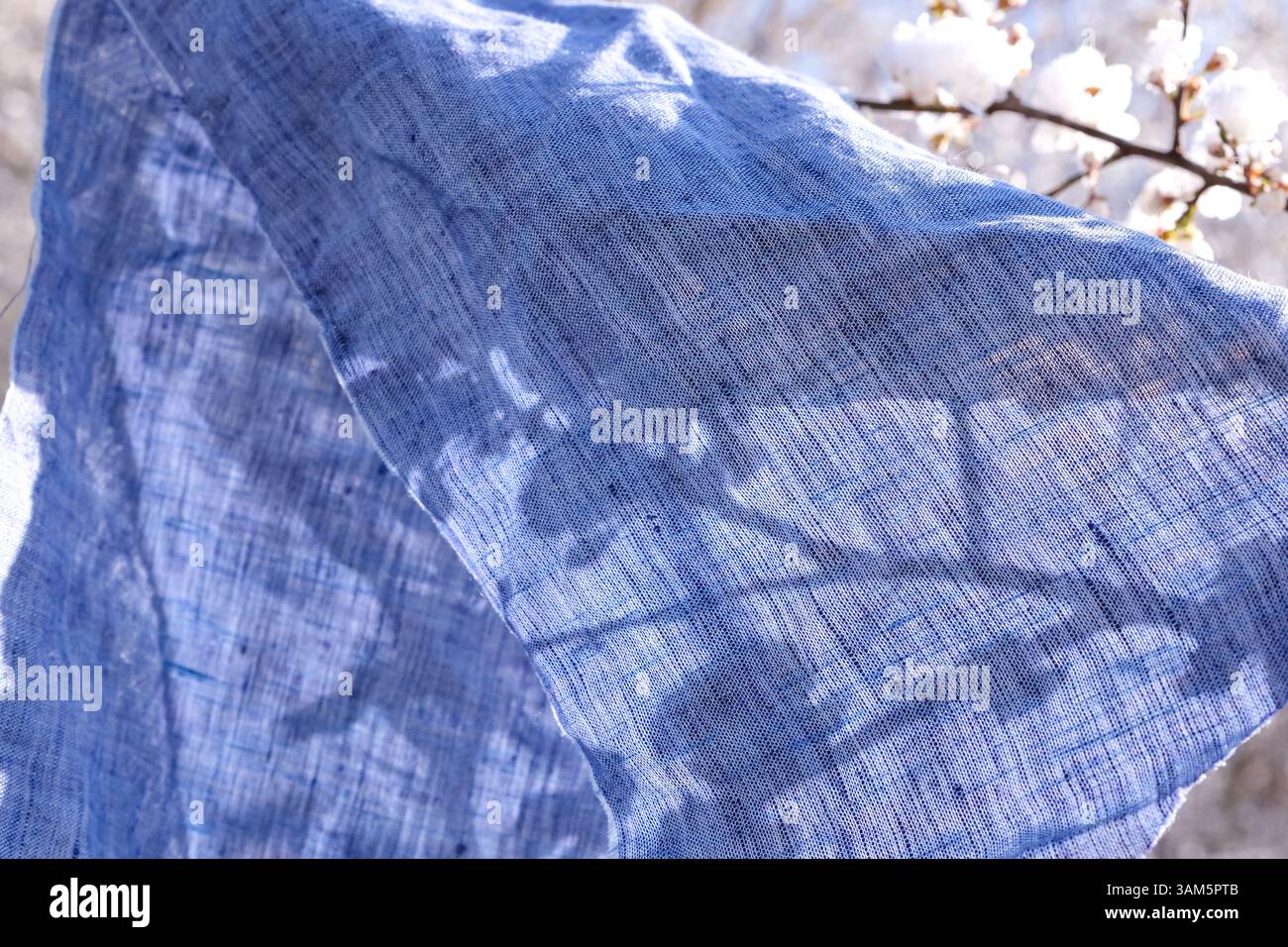 Заголовок zartes und luftiges Material aus blauem Leinen im Frühling. Sanfte Berührung, Nachhaltigkeit und langsames Leben. Stockfoto