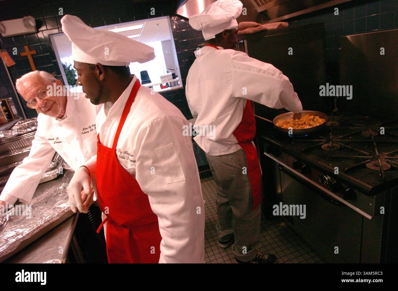 6. April 2005 – US-amerikanische KRT LIFESTYLE STORY SLUGGED: NEWVOICES-SHELTERCHEFS KRT FOTO VON MICHAEL LAUGHLIN/SOUTH FLORIDA SUN-SENTINEL (Miami-Out) (16. Mai) „ Love Thy NEIGHOR““ Programmdirektor Arnold Abbott (links) hilft Nathaniel Bean während James Golson Gemüse sautiert. (jt) 2005 (Vielfalt) (Bild: © Michael Laughlin/mct/ZUMAPRESS.com) Stockfoto