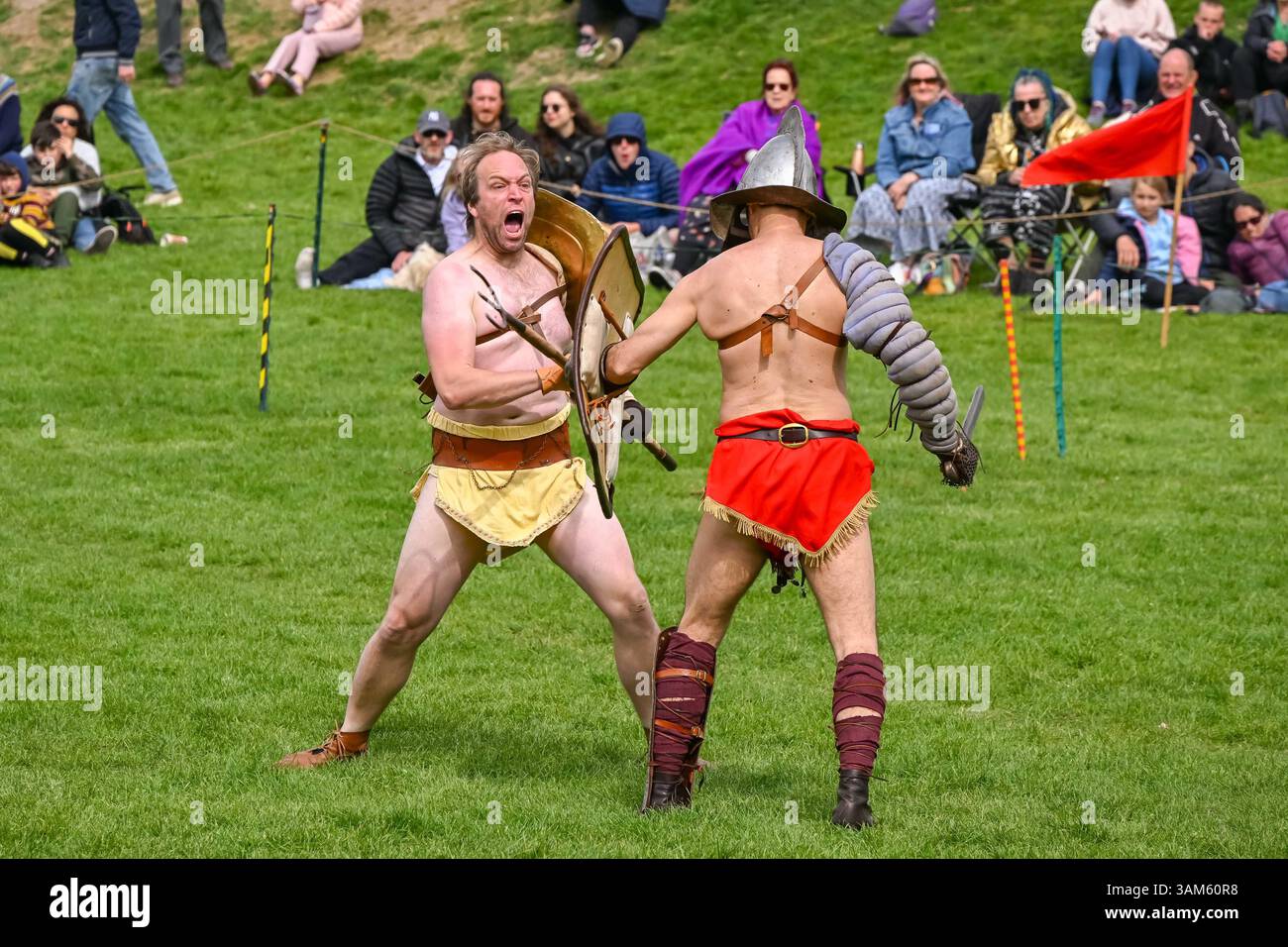 Dorchester, Dorset, Großbritannien. April 2025. Britannia Roman spielt eine Gladiator-Demonstration vor Zuschauern beim Dorchester Roman Festival in Maumbury Rings, Dorchester in Dorset. Die kostenlose Veranstaltung in Maumbury Rings, eine neolithische Henge, die von den Römern um 100 n. Chr. als Amphitheater genutzt wurde, ist Teil einer zweitägigen Veranstaltung, die während der Osterferien an verschiedenen Orten in der Stadt stattfindet. Bildnachweis: Graham Hunt/Alamy Live News Stockfoto