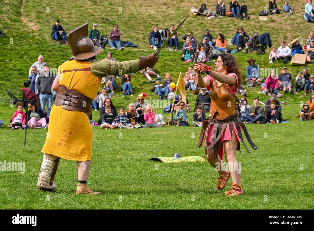 Dorchester, Dorset, Großbritannien. April 2025. Britannia Roman spielt eine Gladiator-Demonstration vor Zuschauern beim Dorchester Roman Festival in Maumbury Rings, Dorchester in Dorset. Die kostenlose Veranstaltung in Maumbury Rings, eine neolithische Henge, die von den Römern um 100 n. Chr. als Amphitheater genutzt wurde, ist Teil einer zweitägigen Veranstaltung, die während der Osterferien an verschiedenen Orten in der Stadt stattfindet. Bildnachweis: Graham Hunt/Alamy Live News Stockfoto