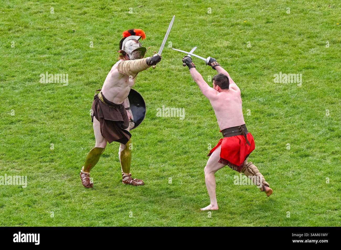 Dorchester, Dorset, Großbritannien. April 2025. Britannia Roman spielt eine Gladiator-Demonstration vor Zuschauern beim Dorchester Roman Festival in Maumbury Rings, Dorchester in Dorset. Die kostenlose Veranstaltung in Maumbury Rings, eine neolithische Henge, die von den Römern um 100 n. Chr. als Amphitheater genutzt wurde, ist Teil einer zweitägigen Veranstaltung, die während der Osterferien an verschiedenen Orten in der Stadt stattfindet. Bildnachweis: Graham Hunt/Alamy Live News Stockfoto