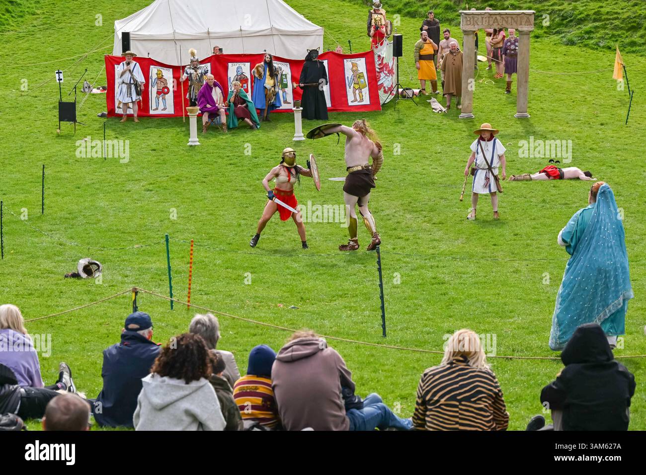 Dorchester, Dorset, Großbritannien. April 2025. Britannia Roman spielt eine Gladiator-Demonstration vor Zuschauern beim Dorchester Roman Festival in Maumbury Rings, Dorchester in Dorset. Die kostenlose Veranstaltung in Maumbury Rings, eine neolithische Henge, die von den Römern um 100 n. Chr. als Amphitheater genutzt wurde, ist Teil einer zweitägigen Veranstaltung, die während der Osterferien an verschiedenen Orten in der Stadt stattfindet. Bildnachweis: Graham Hunt/Alamy Live News Stockfoto