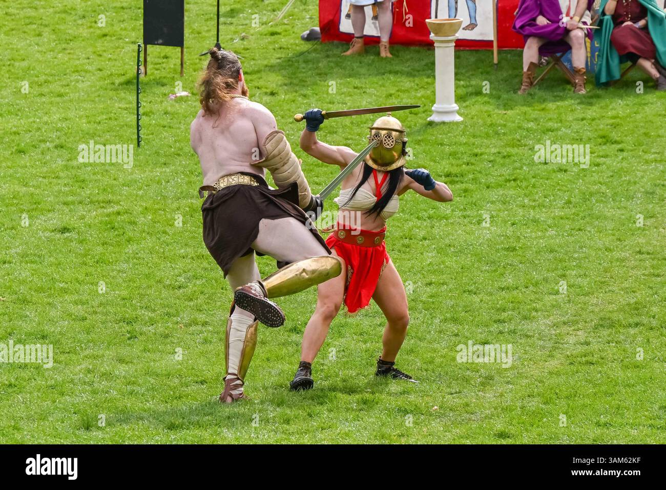 Dorchester, Dorset, Großbritannien. April 2025. Britannia Roman spielt eine Gladiator-Demonstration vor Zuschauern beim Dorchester Roman Festival in Maumbury Rings, Dorchester in Dorset. Die kostenlose Veranstaltung in Maumbury Rings, eine neolithische Henge, die von den Römern um 100 n. Chr. als Amphitheater genutzt wurde, ist Teil einer zweitägigen Veranstaltung, die während der Osterferien an verschiedenen Orten in der Stadt stattfindet. Bildnachweis: Graham Hunt/Alamy Live News Stockfoto