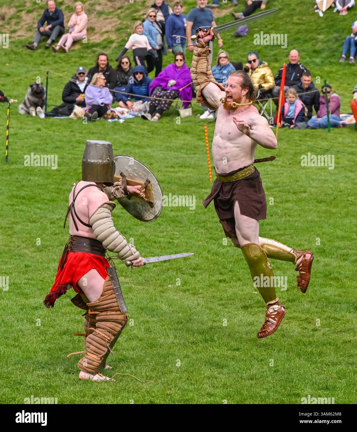 Dorchester, Dorset, Großbritannien. April 2025. Britannia Roman spielt eine Gladiator-Demonstration vor Zuschauern beim Dorchester Roman Festival in Maumbury Rings, Dorchester in Dorset. Die kostenlose Veranstaltung in Maumbury Rings, eine neolithische Henge, die von den Römern um 100 n. Chr. als Amphitheater genutzt wurde, ist Teil einer zweitägigen Veranstaltung, die während der Osterferien an verschiedenen Orten in der Stadt stattfindet. Bildnachweis: Graham Hunt/Alamy Live News Stockfoto