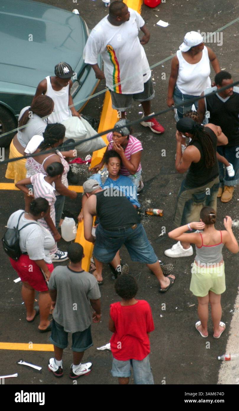 1. September 2005 - USA - KRT US NEWS STORY SCHLEPPTE: WEA-KATRINA KRT FOTO VON TRAVIS HEYING/WICHITA EAGLE (1. September) NEW ORLEANS, LA -- Eine Frau (in blau) liegt am Donnerstag, 1. September 2005 am Boden vor dem New Orleans Convention Center. Tausende warteten auf dem Gehweg vor dem Kongresszentrum in der Hoffnung, eine Busfahrt aus der Stadt zu machen. (cdm) 2005 (Kreditbild: © Travis Heying/mct/ZUMAPRESS.com) Stockfoto