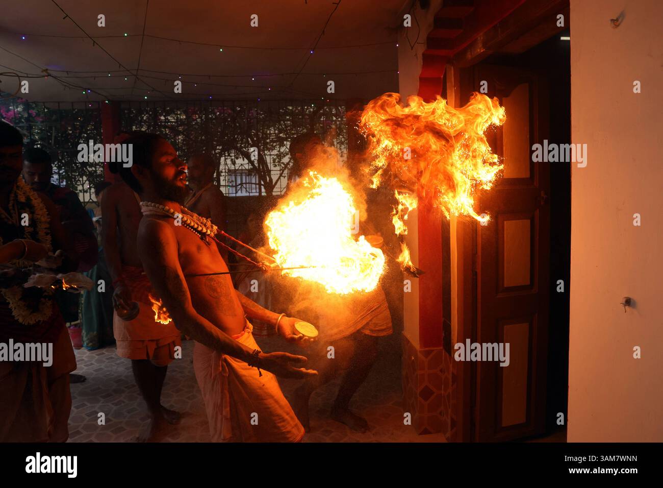 Gajan-Festivalrituale in Westbengalen, Indien Ein Gläubiger schleudert Feuer in Richtung eines Tempels als Teil eines Ritual, das den Abschluss einer religiösen Prozession für das Gajan-Festival am 13. April 2025 im Bezirk Parganas, Westbengalen, Indien markiert. Hunderte hingebungsvoller Gläubiger kommen zusammen, um intensive Hingabe zu verüben und den Segen des hinduistischen Gottes Shiva zu suchen. Das Gajan-Festival, das mit leidenschaftlichen Ritualen und symbolischen Bußtaten gefeiert wird, markiert das Ende des bengalischen Kalenderjahres und soll den Wünschen der Teilnehmer entsprechen. Kalkutta Indien Copyright: XMatrixxImage Stockfoto Gajan-Festivalrituale in Westbengalen, Indien Ein Gläubiger schleudert Feuer in Richtung eines Tempels als Teil eines Ritual, das den Abschluss einer religiösen Prozession für das Gajan-Festival am 13. April 2025 im Bezirk Parganas, Westbengalen, Indien markiert. Hunderte hingebungsvoller Gläubiger kommen zusammen, um intensive Hingabe zu verüben und den Segen des hinduistischen Gottes Shiva zu suchen. Das Gajan-Festival, das mit leidenschaftlichen Ritualen und symbolischen Bußtaten gefeiert wird, markiert das Ende des bengalischen Kalenderjahres und soll den Wünschen der Teilnehmer entsprechen. Kalkutta Indien Copyright: XMatrixxImage Stockfoto