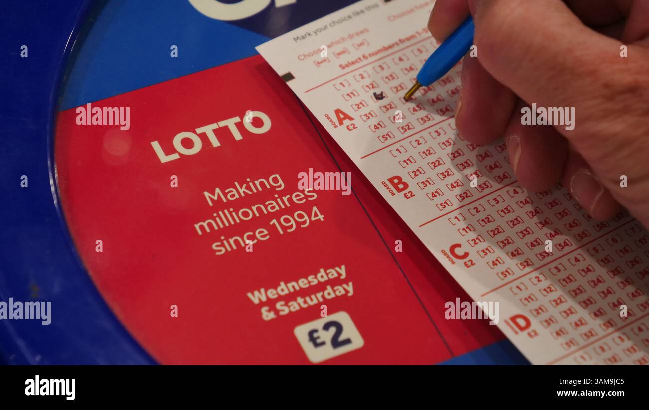 Ein Spieler der Nationallotterie in Großbritannien wählt die Zahlen für sein Lottoticket aus. Stockfoto