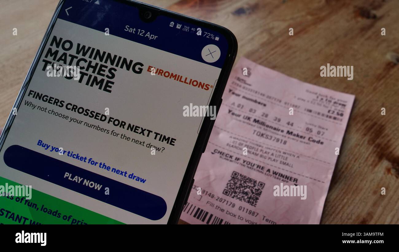 Ein Lottospieler prüft sein Lottoticket in der National Lottery App und stellt fest, dass er keine Gewinnspiele hat Stockfoto