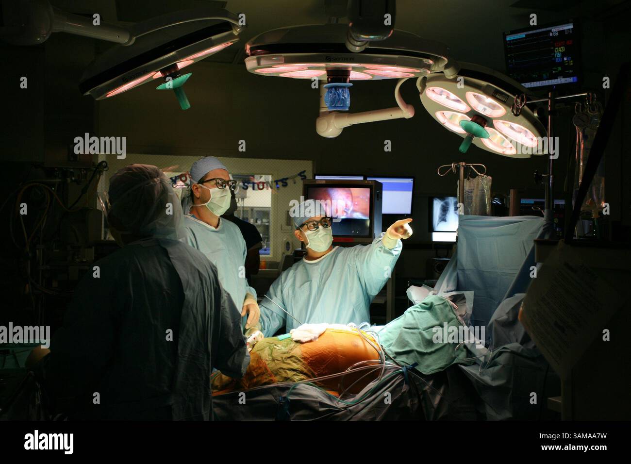 12. Juli 2007 – USA – der Assistent des Arztes Jeff Mello unterstützt Herz-Kreislauf- und Thoraxchirurg James Longoria (Mitte) schaut auf einen Monitor, während er im Sutter Memorial Hospital ein Labyrinth-Verfahren durchführt, auf dem Herzen eines 50-jährigen Mannes, der an Vorhofflimmern - einem abnormen Herzrhythmus - leidet. Longoria hat eine weniger invasive Methode entwickelt, um die Operation durchzuführen, Donnerstag, den 12. Juli 2007. (Randy Pench/Sacramento Bee/MCT) (Kreditbild: © Randy Pench/mct/ZUMAPRESS.com) Stockfoto