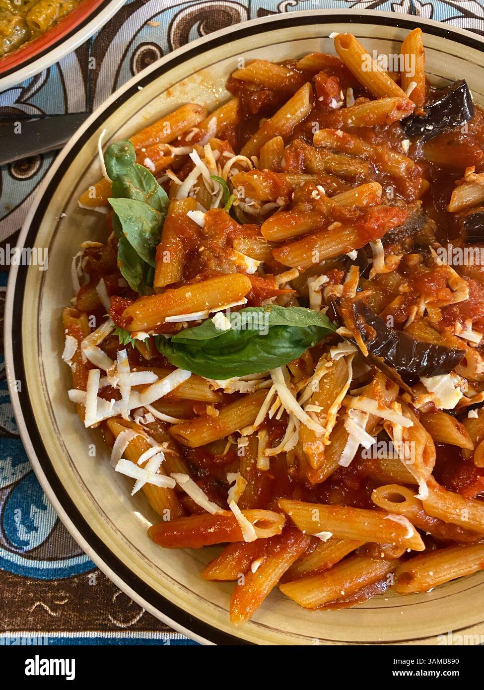 Sizilianische Penne-Pasta mit Tomatensauce, Aubergine, Käse und Basilikum Stockfoto