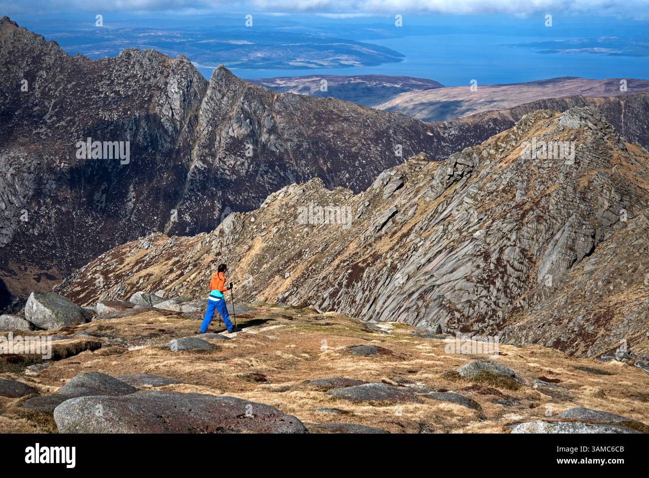 Junge Frau Bergwandererin direkt unterhalb des Gipfels von Goatfell auf der Isle of Arran, North Ayrshire, Schottland, Großbritannien. Stockfoto