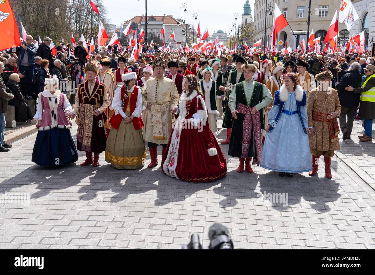 In traditioneller Tracht gekleidete Menschen führen das polonez auf, während sie am 1000. Jahrestag der ersten polnischen Königskrönung in Warschau teilnehmen. In Warschau fand ein marsch zum 1000. Jahrestag des polnischen Königreichs und zum 500. Jahrestag der preußischen Hommage statt. Tausende von Teilnehmern, viele mit weißen und roten Fahnen und Bannern, gingen durch die Straßen und skandierten Slogans wie „Republik“ und „Don't Fear Tusk“. Gegen Mittag nahm Jaroslaw Kaczynski an der Veranstaltung Teil, wie zuvor angekündigt. Um 14:00 Uhr wurde Karol Nawrocki, der Präsidentschaftskandidat, unterstützt durch das Gesetz und Stockfoto