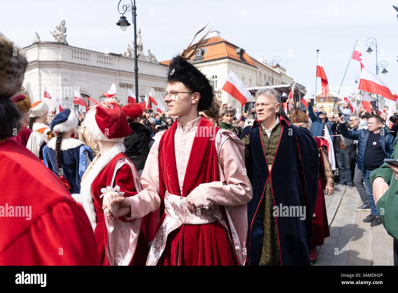 In traditioneller Tracht gekleidete Menschen führen das polonez auf, während sie am 1000. Jahrestag der ersten polnischen Königskrönung in Warschau teilnehmen. In Warschau fand ein marsch zum 1000. Jahrestag des polnischen Königreichs und zum 500. Jahrestag der preußischen Hommage statt. Tausende von Teilnehmern, viele mit weißen und roten Fahnen und Bannern, gingen durch die Straßen und skandierten Slogans wie „Republik“ und „Don't Fear Tusk“. Gegen Mittag nahm Jaroslaw Kaczynski an der Veranstaltung Teil, wie zuvor angekündigt. Um 14:00 Uhr wurde Karol Nawrocki, der Präsidentschaftskandidat, unterstützt durch das Gesetz und Stockfoto