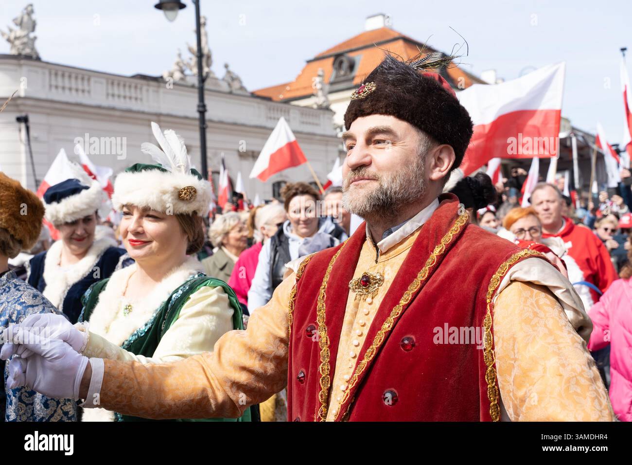 In traditioneller Tracht gekleidete Menschen führen das polonez auf, während sie am 1000. Jahrestag der ersten polnischen Königskrönung in Warschau teilnehmen. In Warschau fand ein marsch zum 1000. Jahrestag des polnischen Königreichs und zum 500. Jahrestag der preußischen Hommage statt. Tausende von Teilnehmern, viele mit weißen und roten Fahnen und Bannern, gingen durch die Straßen und skandierten Slogans wie „Republik“ und „Don't Fear Tusk“. Gegen Mittag nahm Jaroslaw Kaczynski an der Veranstaltung Teil, wie zuvor angekündigt. Um 14:00 Uhr wurde Karol Nawrocki, der Präsidentschaftskandidat, unterstützt durch das Gesetz und Stockfoto