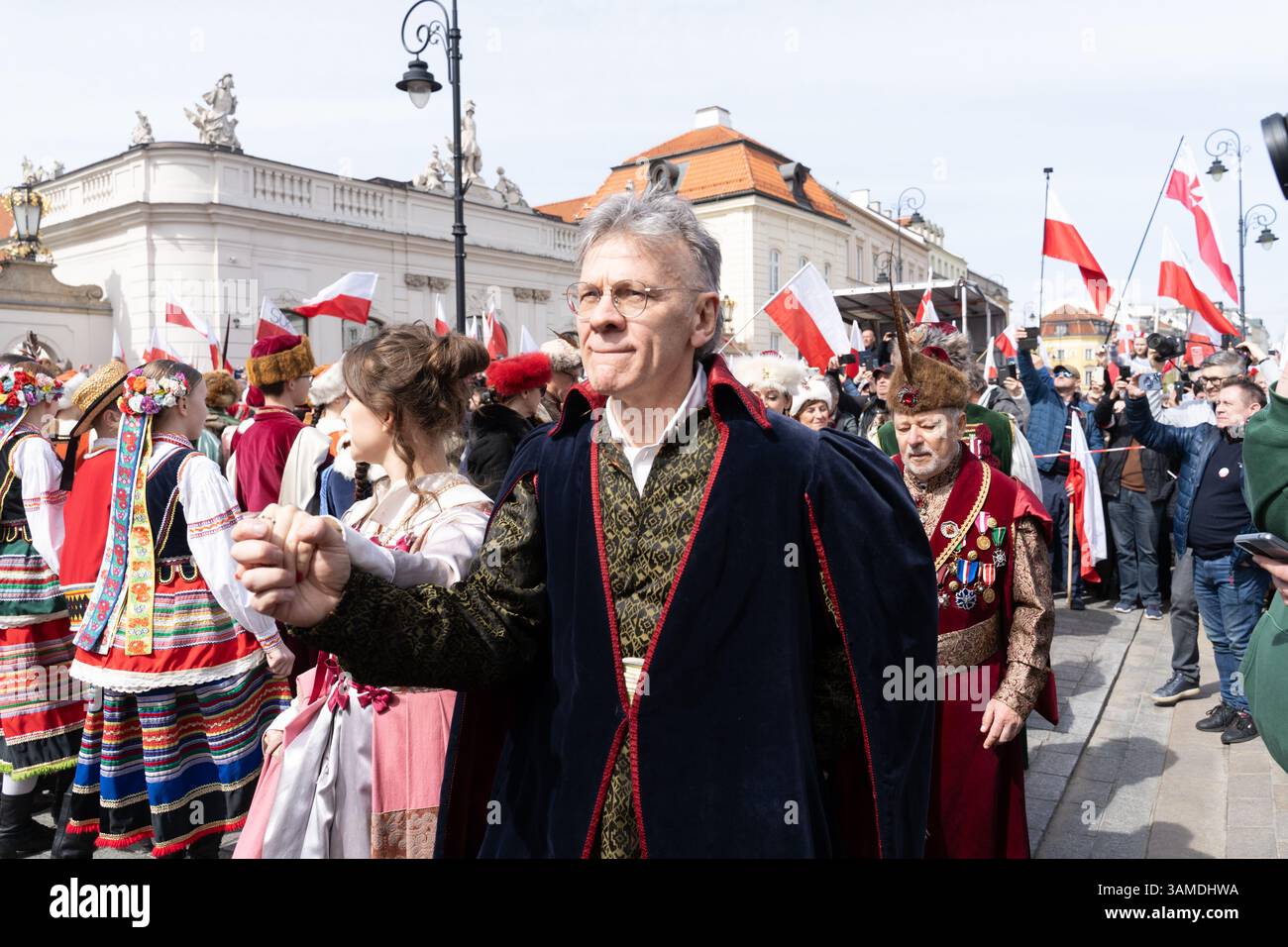 In traditioneller Tracht gekleidete Menschen führen das polonez auf, während sie am 1000. Jahrestag der ersten polnischen Königskrönung in Warschau teilnehmen. In Warschau fand ein marsch zum 1000. Jahrestag des polnischen Königreichs und zum 500. Jahrestag der preußischen Hommage statt. Tausende von Teilnehmern, viele mit weißen und roten Fahnen und Bannern, gingen durch die Straßen und skandierten Slogans wie „Republik“ und „Don't Fear Tusk“. Gegen Mittag nahm Jaroslaw Kaczynski an der Veranstaltung Teil, wie zuvor angekündigt. Um 14:00 Uhr wurde Karol Nawrocki, der Präsidentschaftskandidat, unterstützt durch das Gesetz und Stockfoto