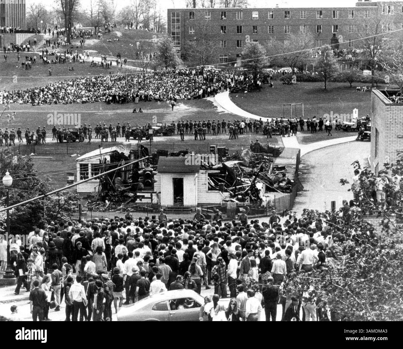 4. Mai 1970: Das in Kent, Ohio, USA, verbrannte ROTC-Gebäude ist eingezäunt, da Demonstranten, Ohio National Guardsmen und Zuschauer das Kent State Commons füllen, nachdem Studenten während der Antikriegsproteste auf dem Campus am 4. Mai 1970 erschossen wurden. Die Erschießungen des Kent State (auch bekannt als das Massaker am 4. Mai oder das Massaker am Kent State) ereigneten sich an der Kent State University in der US-Stadt Kent, Ohio, und beinhalteten die Erschießung unbewaffneter Studenten durch die Ohio National Guard am Montag, den 4. Mai 1970. Die Wachmänner feuerten 67 Runden über einen Zeitraum von 13 Sekunden ab, töteten vier Schüler und verletzten neun weitere Stockfoto
