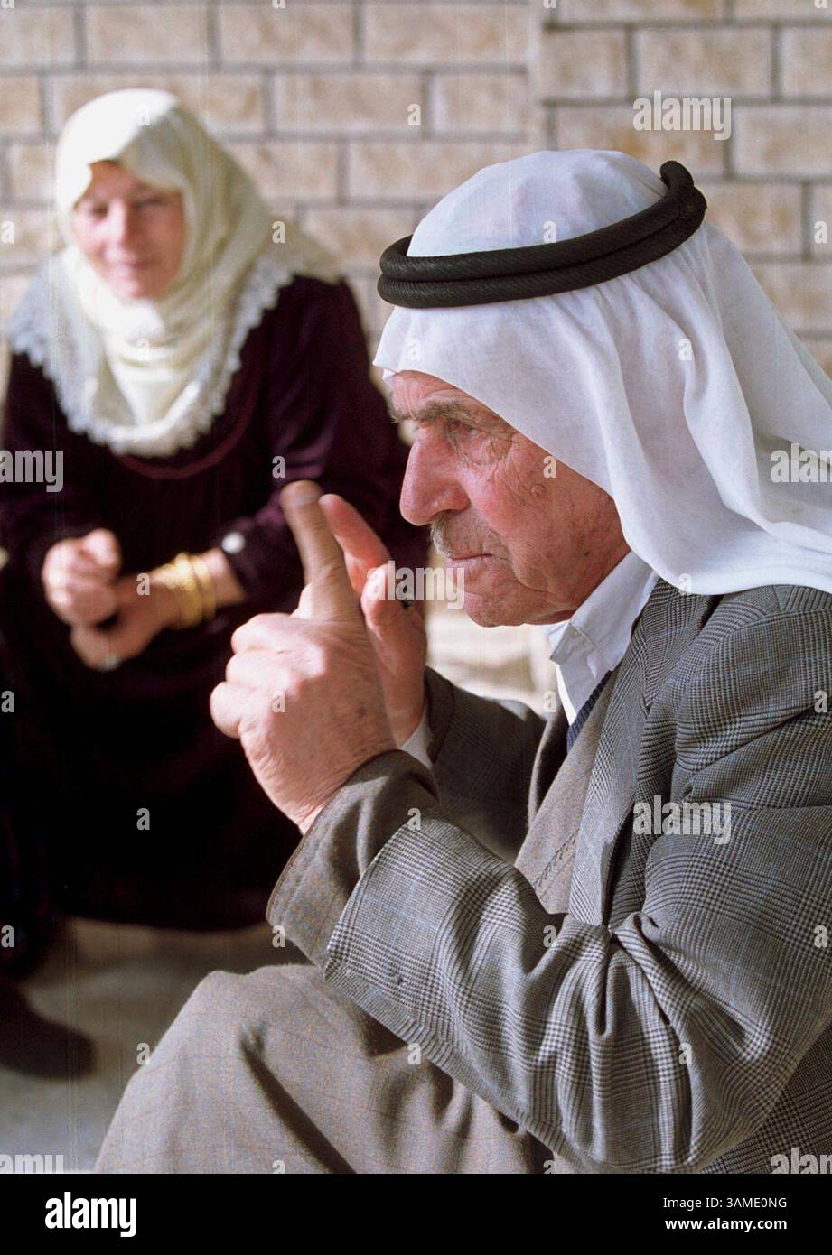 25. Januar 2001 - STAMP, US - (KRT7) KRT WORLD NEWS STORY SLUGGED: MIDEAST KRT FOTO VON EVELYN HOCKSTEIN/KRT (25. Januar) Nimir Ghanayem, 77, spricht über die bevorstehenden israelischen Wahlen in seinem Haus im arabisch-israelischen Dorf Sakhnin, während seine Frau Rashida am 22. Januar 2001 schaut. Israels arabische Bürger drohen, die Wahlen zum Premierminister am 6. Februar zu boykottieren, was dem harten Likud-Führer Ariel Sharon helfen wird. (KRT) PL BL KD 2001 (VERT.) (kn) (Bild: © PHOTOGNOSOURCE/mct/ZUMAPRESS.com) Stockfoto