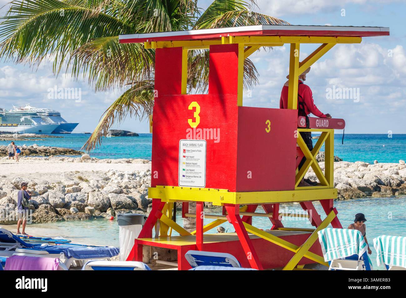 Toller Stirrup Cay die Bahamas, rot gelber Rettungsschirm Turm 3, Warnflagge am Strand, Mann männlicher Rettungsschwimmer sitzend Aussichtspunkt, Kreuzfahrtschiff am Meer Hintergrund, Co Stockfoto
