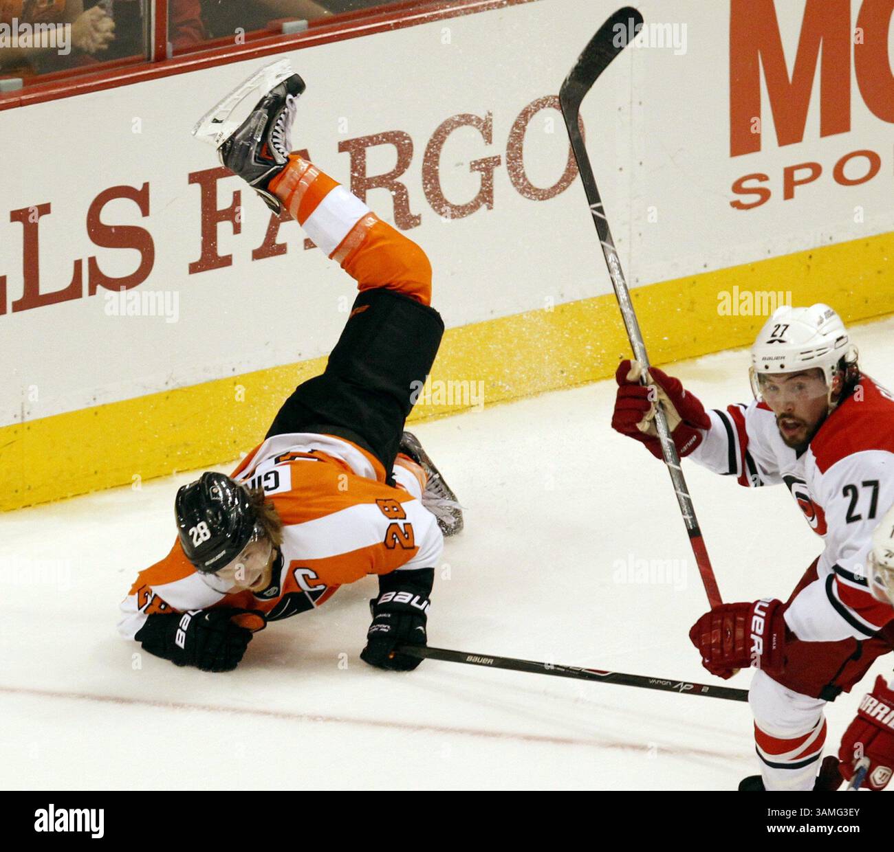 13. April 2014 – Philadelphia, PA, USA – die Philadelphia Flyers’ Claude Giroux wird während der Spieletage im Wells Fargo Center in Philadelphia am Sonntag, den 13. April 2014 von Justin Faulk der Carolina Hurricanes gestolpert. Die Hurricanes schlugen die Flyers in einer Schießerei, 6:5. (Kreditbild: © Ron Cortes/MCT/ZUMAPRESS.com) Stockfoto