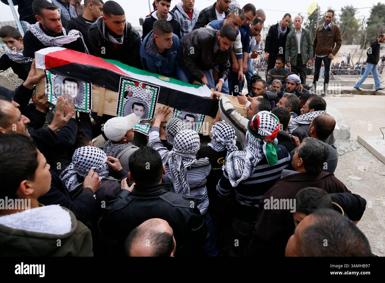 27. Januar 2014 – Husan, Bethlehem, Westjordanland – Palästinenser begraben die Überreste von Shadi Hamamreh, der im März 2002 von der israelischen Armee getötet wurde, nachdem seine Überreste von den Israelis zurückgegeben worden waren. Israel wird 36 Leichen nach einem Urteil des Obersten Gerichtshofs an das Westjordanland zur Wiederbeerdigung überweisen. (Kreditbild: © Mustafa Bader/ZUMAPRESS.com) Stockfoto