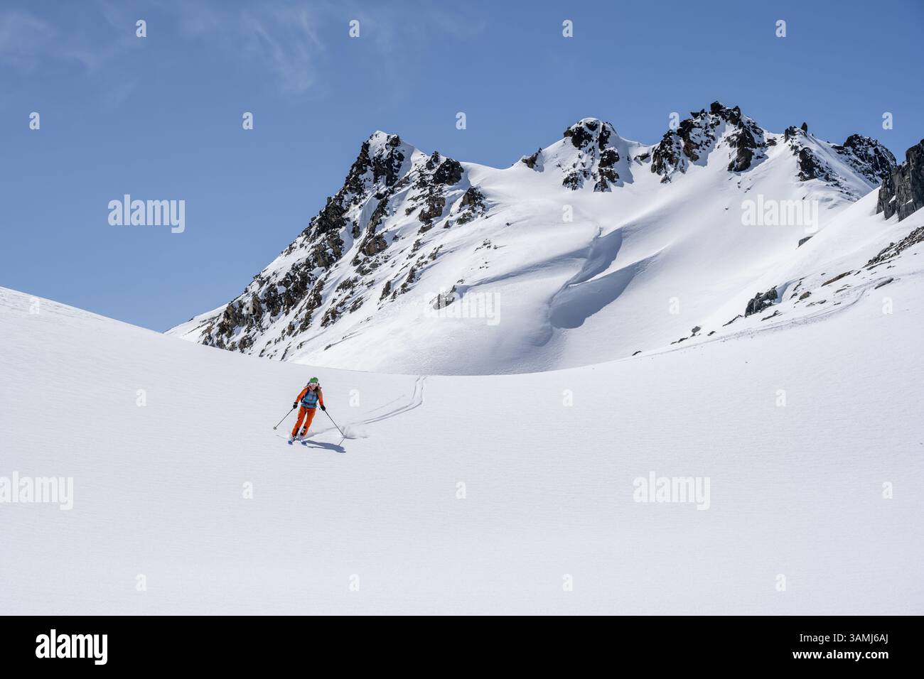 Skitourer auf der Abfahrt, minimalistische Winterlandschaft, weißer Schnee und dunkle Berge auf dem Scalettahorn, Graubünden, Schweiz, Europa Stockfoto