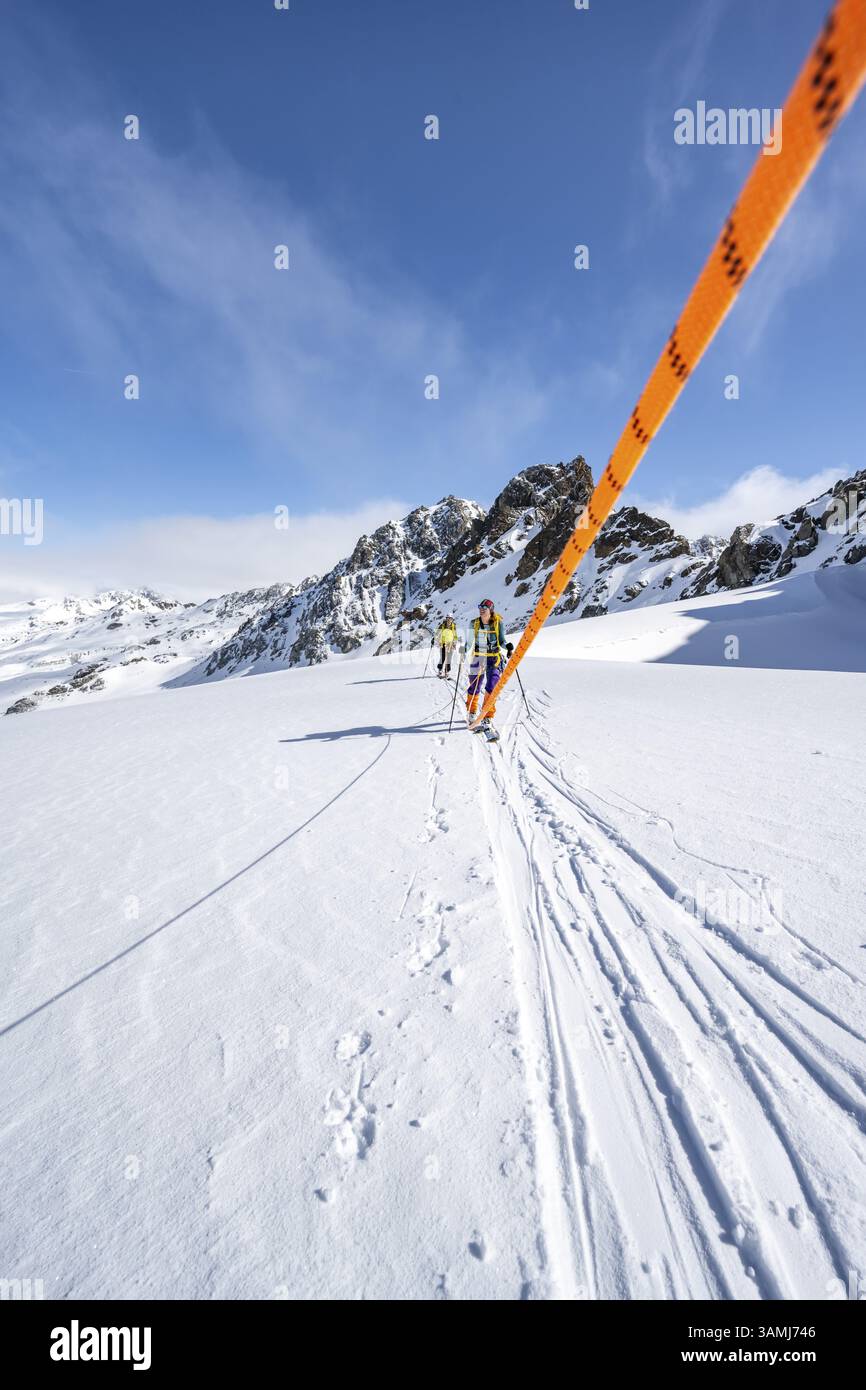 Skitourer mit Seil, Seilteam auf dem Gletscher Vadret da Porchabella beim Aufstieg zum Gipfel des Piz Kesch, Berglandschaft im Winter, alpines To Stockfoto