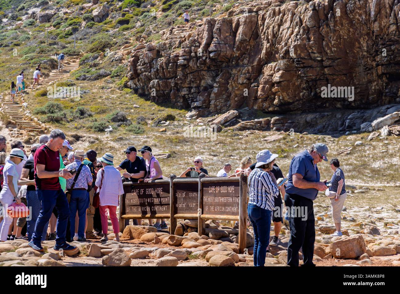 Touristen drängen sich, um Fotos mit dem berühmten Namensschild am Kap der Guten Hoffnung auf der Kap-Halbinsel in Kapstadt, Westkap, Südafrika zu machen Stockfoto