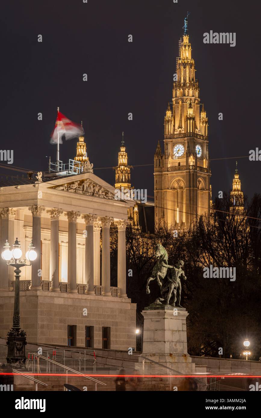 Nachtansicht auf das österreichische Parlamentsgebäude und das Wiener Rathaus im Hintergrund, Wien, Österreich Stockfoto