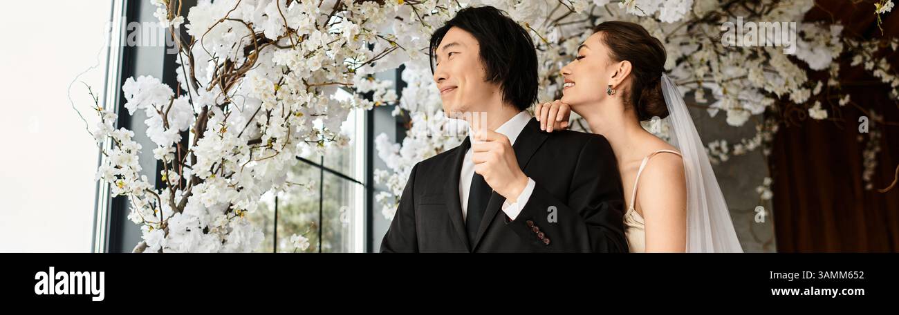 Ein liebevolles Paar teilt einen zärtlichen Moment, umgeben von eleganten Blumen, versprühen Romantik. Stockfoto