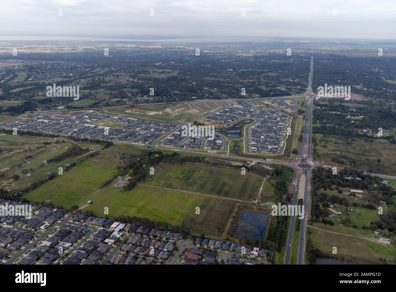 Aus der Vogelperspektive der Wohnsiedlung mit Straßen und Feldern, umgeben von Grün, Cranbourne West, Australien. Stockfoto