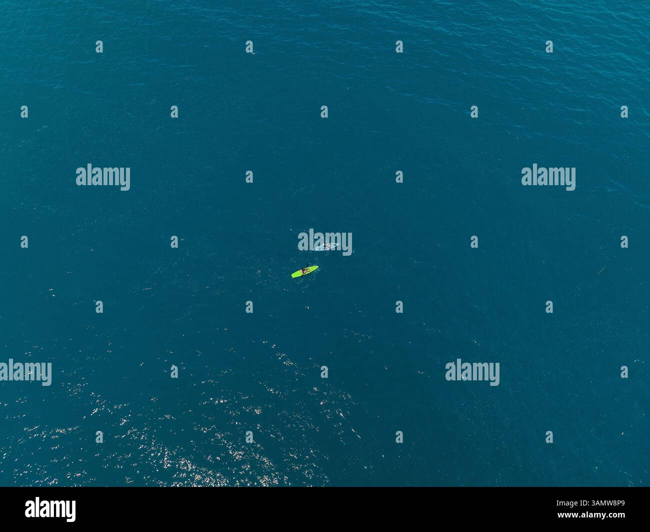 Aus der Vogelperspektive von zwei winzigen Leuten, die in Milazzo, Sizilien, Italien, mit dem Kanu ins Meer fahren. Stockfoto